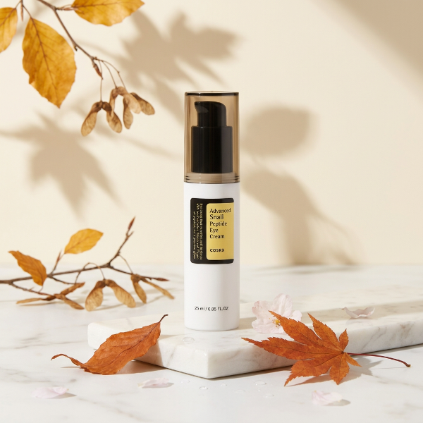 COSRX Snail Peptide Eye Cream pe suport de marmură în decor de toamnă